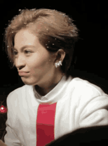a close up of a woman 's face with a white shirt and red stripe