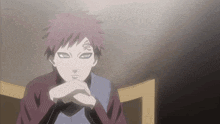 a man with red hair and a tattoo on his face sits in a chair