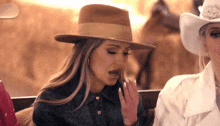 a woman wearing a hat and a cowboy hat
