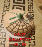 a halloween cake with spiders on it and the words happy halloween in red