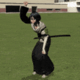 a female anime character is holding a sword in a field
