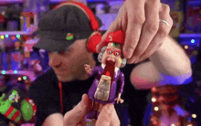 a man in a hat is holding a purple toy