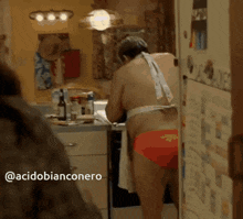 a man in an apron is standing in a kitchen next to a fridge