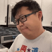 a man wearing glasses and a white shirt with chinese writing