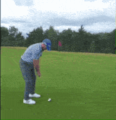 a man is swinging a golf club on a green
