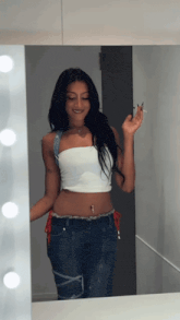 a woman standing in front of a mirror holding a cigarette