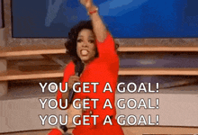 oprah winfrey is holding a microphone and saying `` you get a goal ! ''