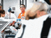 a man wearing an orange vest that says emergency medical