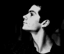 a black and white photo of a young man with a nose ring