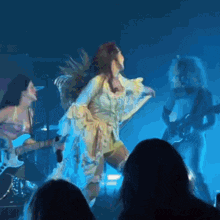 a woman in a yellow dress is singing into a microphone in front of a crowd