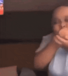 a blurry picture of a person eating a donut in front of a tv .