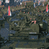 a man in a military uniform salutes while sitting on a tank