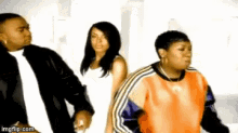 a man and two women are standing next to each other .