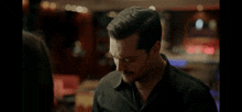 a man in a black shirt is looking down