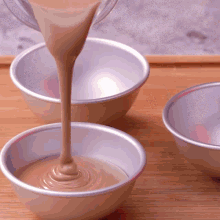 a bowl of liquid is being poured into another bowl of liquid