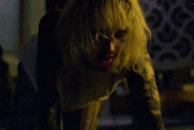 a woman with blonde hair and a tattoo on her arm