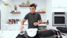 a man prepares food in a kitchen with a panissang pinoy logo on the wall above him