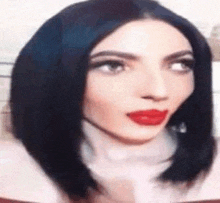 a close up of a woman 's face with red lipstick and blue hair .