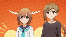 a girl with antlers on her head stands next to a girl in a black shirt