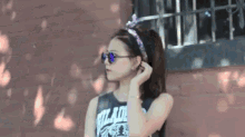 a woman wearing sunglasses and a headband that says ' wizard ' on it