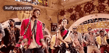 a group of people are dancing in a room with a stained glass window .