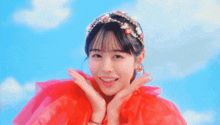 a girl wearing a red dress and a headband with flowers on it is smiling
