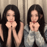 two girls are making faces with their hands