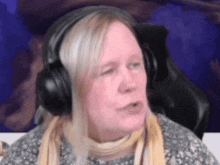 a woman wearing headphones is sitting in a chair .