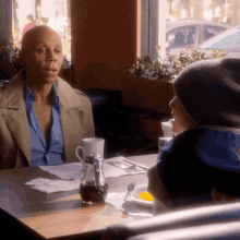 a man and a child sit at a table talking