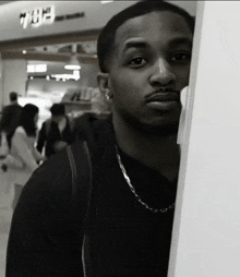 a black and white photo of a man in front of a sign that says ' eh3 '