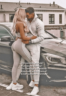a man and woman kissing in front of a car
