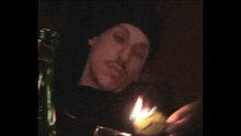 a man is lighting a candle with a lighter in a dark room .