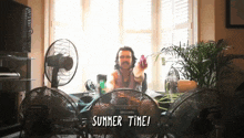 a man sitting in front of a bunch of fans with the words summer time written on the bottom