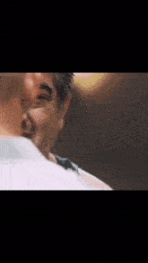 a close up of a man making a funny face while talking to another man in a dark room .