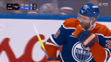 a hockey player for the oilers holds his stick in his hand