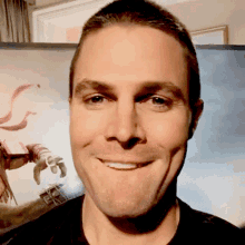 a man is smiling in front of a picture of a robot