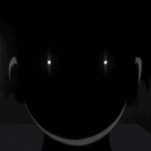 a silhouette of a person 's face with glowing eyes in the dark .
