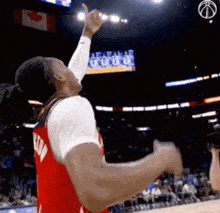 a basketball player wearing a red jersey with the word raptors on the back