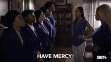 a group of women standing next to each other with the words have mercy