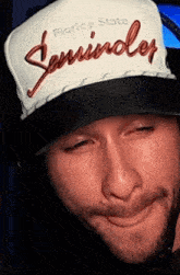 a man wearing a florida state seminole hat makes a face