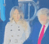 a woman in a trench coat stands next to donald trump