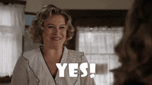 a woman in a white robe is smiling and says " yes "