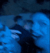 a woman is covering her mouth with her hand in a crowd of people .