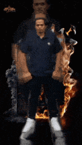a man in a blue shirt is surrounded by a circle of flames