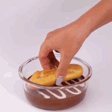 a person dipping a cookie in chocolate sauce