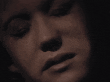 a close up of a woman 's face with her eyes closed in a black and white photo .