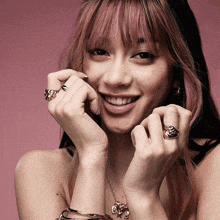 a woman with pink hair and rings on her hands