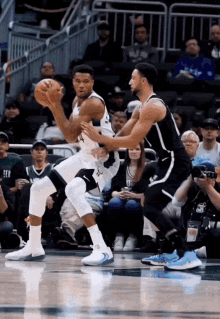 a basketball player dribbles the ball while another player watches