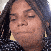 a close up of a woman with braids making a funny face .