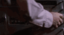 a close up of a man 's hand pressing a button on a stove